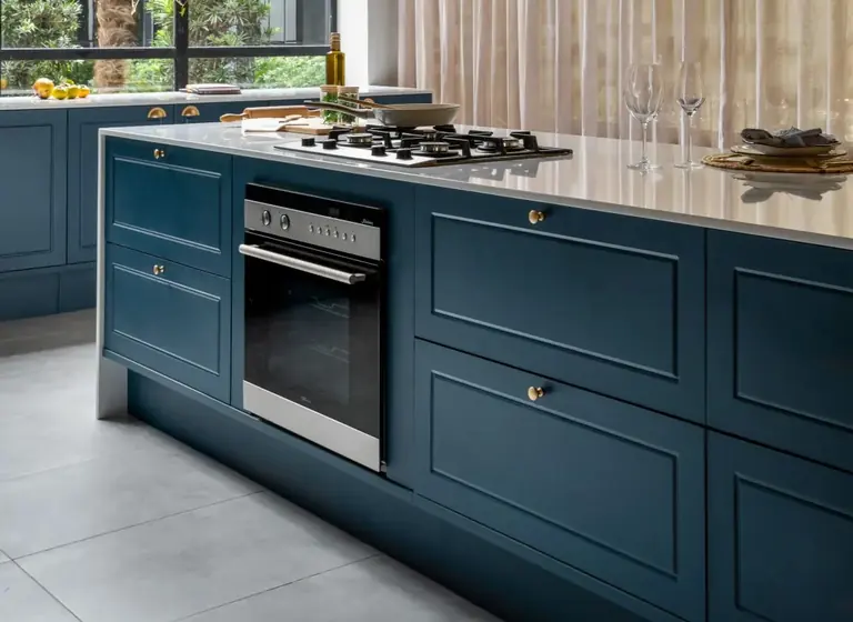 Detalhe de ilha de cozinha planejada em tom azul com cooktop embutido